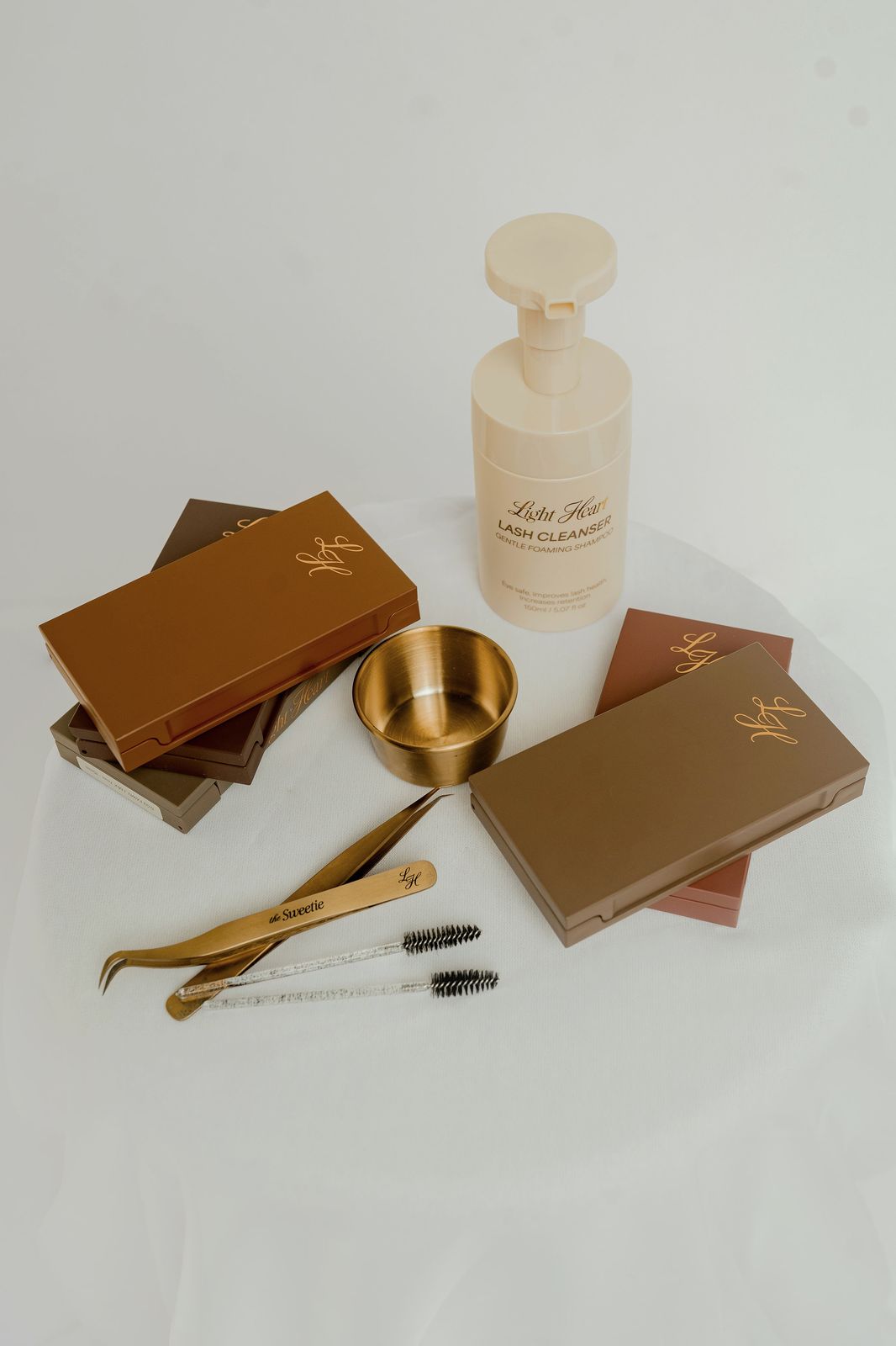Light Heart Lash products styled with gold tools